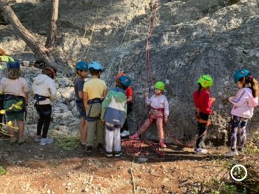 Un groupe d'enfant qui apprend l'escalade en extérieur